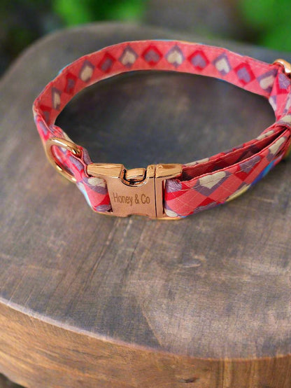 Stylish Honey's Hearts Dog Collar by Honey & Co showcasing a heart pattern and gold clasp, placed on a wooden platform.